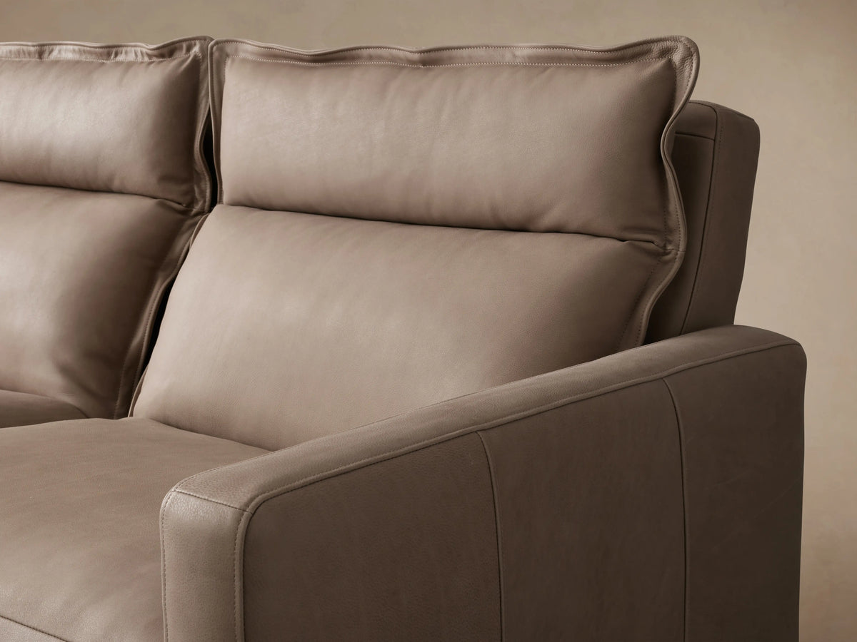 Rowland Leather Three-Piece Motion Modular Sofa in brown leather with three reclinable sections. Viewed from the front on wood flooring against a beige wall.