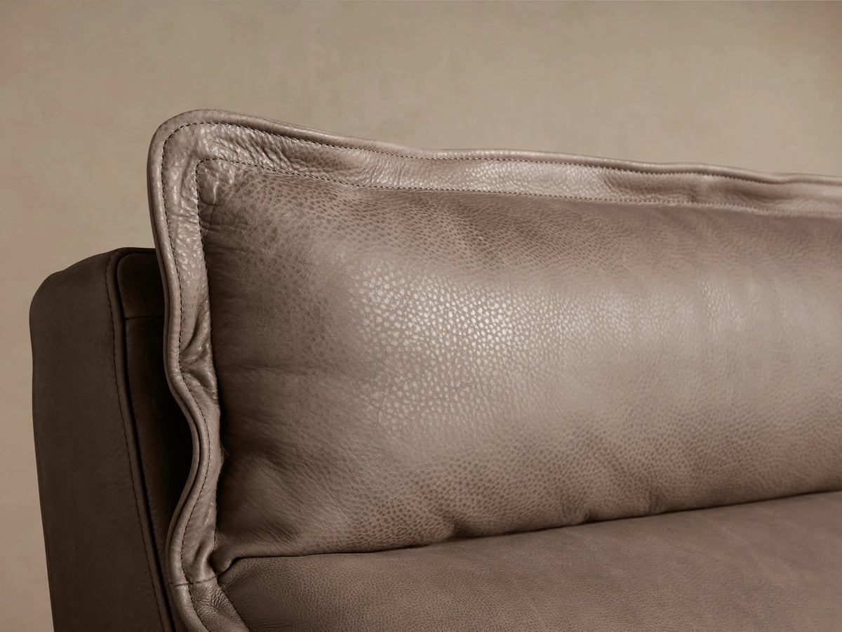 Rowland Leather Four-Piece Armless Motion Modular Sofa, brown leather, four recliners in a row on wooden floor, beige background.