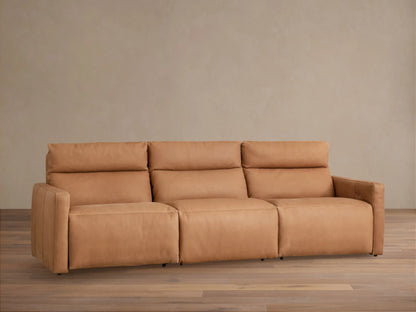 Rowland Tailored Leather Three-Piece Motion Modular Sofa, tan leather, front view. Sits on a wooden floor against a beige wall.
