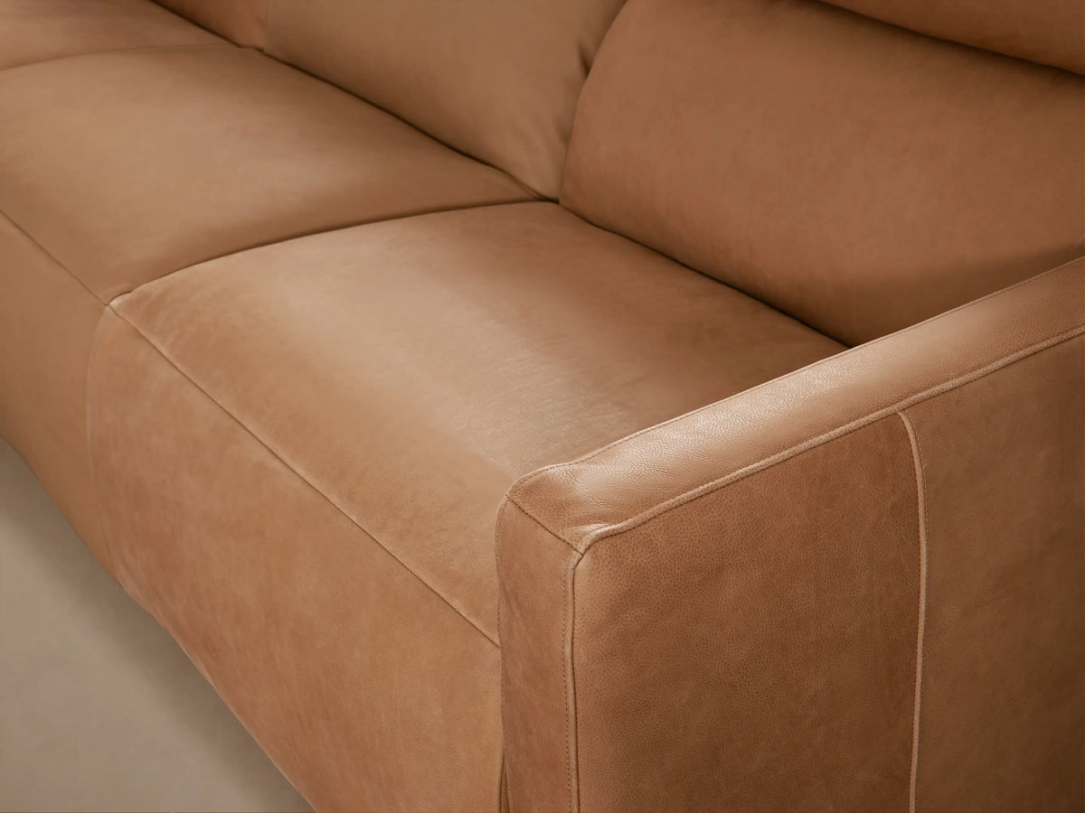 Full view of Rowland three-piece modular motion sofa, light brown tailored leather, featuring three seats and two armrests.