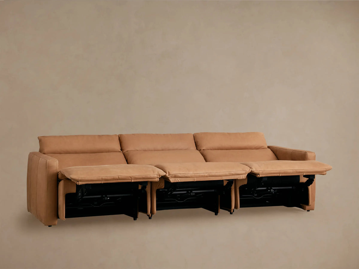 Rowland Tailored Leather Three-Piece Motion Modular Sofa in tan, fully reclined, showing extended footrests on beige wall.