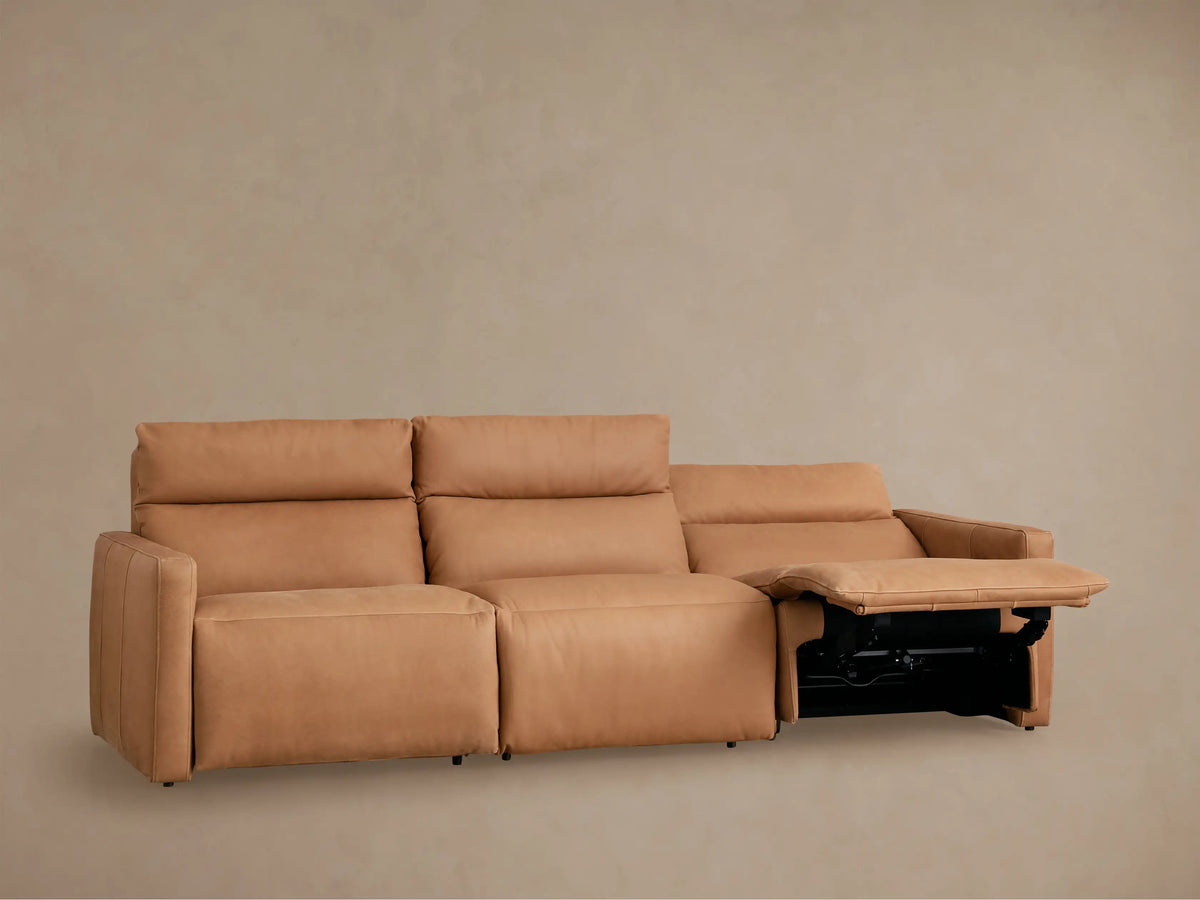 Rowland Tailored Leather Three-Piece Modular Sofa in tan, all sections reclined with footrests extended, against a light wall.