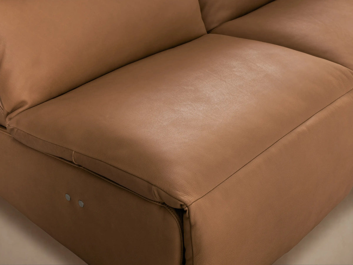 Rowland Tailored Leather Four-Piece Armless Motion Modular Sofa in tan leather, front view, on a wood floor against a beige wall.