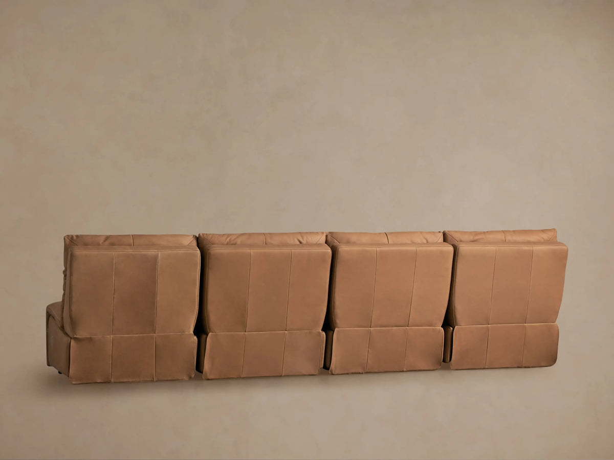 Close-up of a tan leather Rowland Tailored armless modular sofa, showing seat, back cushion, and two silver control buttons.