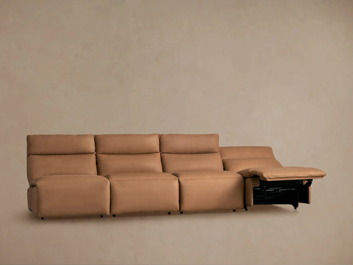 Tan Rowland Tailored Leather 4-piece armless modular sofa, all sections reclining with elevated footrests, against a plain wall.