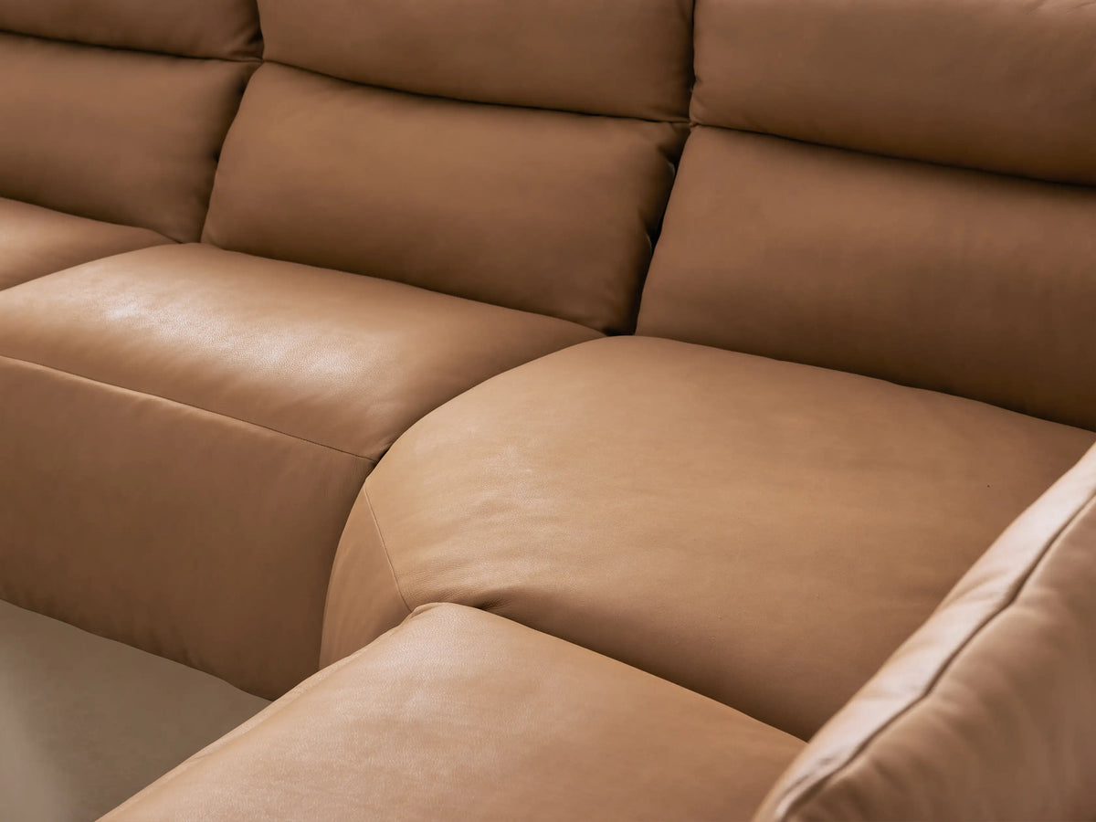 Rowland Tailored tan leather five-piece motion corner sectional sofa on a light wooden floor, against a beige wall.