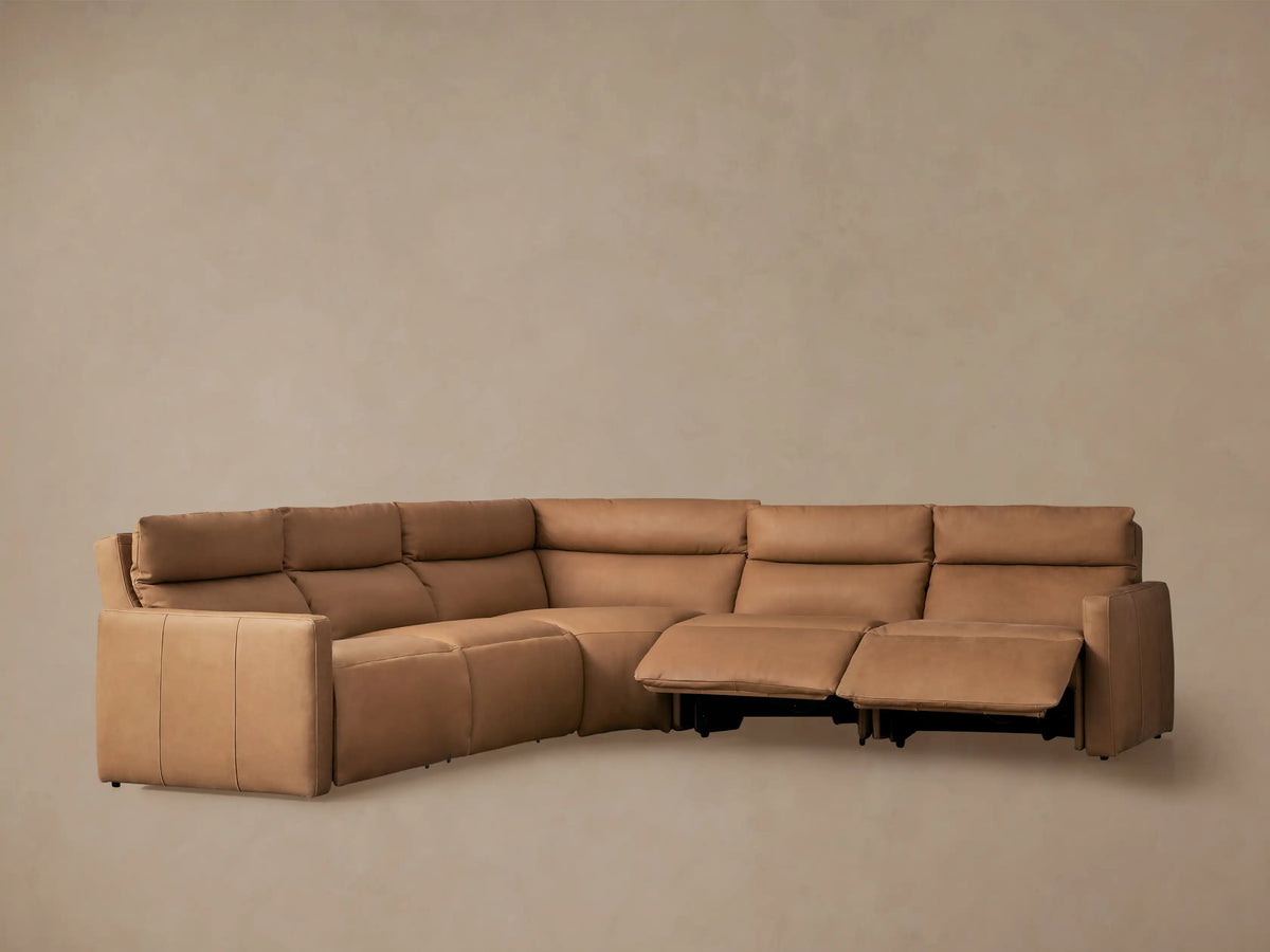 Rowland Tailored tan leather L-shaped 5-piece motion corner sectional, with two recliners extended, against a neutral wall.
