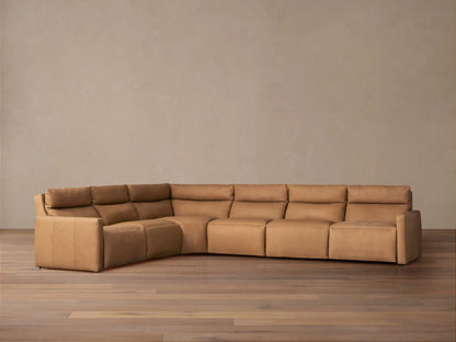 Back view of an L-shaped Rowland Tailored six-piece motion sectional in light brown leather against a plain neutral background.