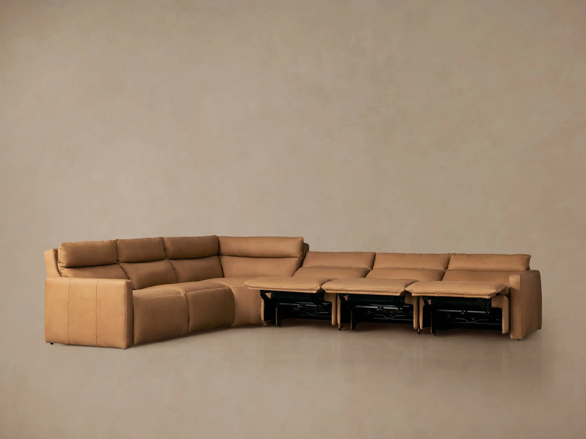 L-shaped Rowland Tailored Leather Six-Piece Motion Sectional in tan, with footrests extended, against a plain background.