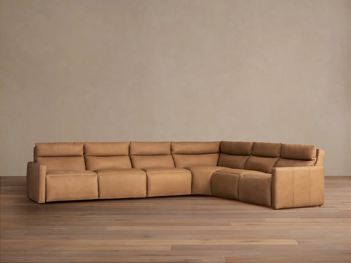 Rowland Tailored Leather Six-Piece Motion Sectional, L-shaped in light brown, with plush cushions, on a wood floor.