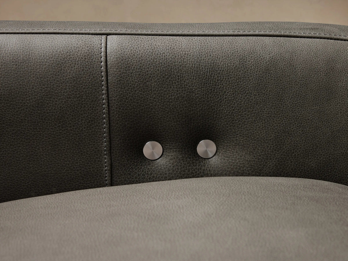 Dark gray leather Rowland Tailored Three-Piece Motion Modular Sofa on a light wood floor against a beige wall.