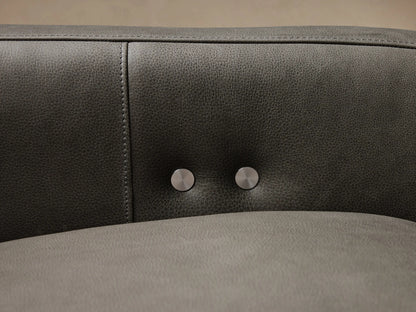 Dark gray leather Rowland Tailored Three-Piece Motion Modular Sofa on a light wood floor against a beige wall.