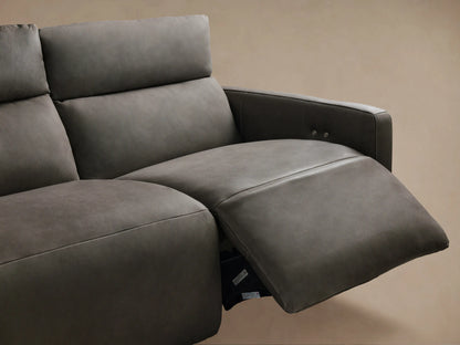 Close-up of Rowland tailored leather sofa, dark gray textured backrest with vertical stitching, two silver buttons, above a lighter gray seat.