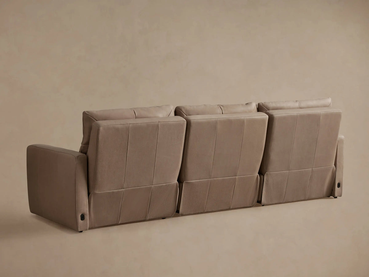 Close-up of a light beige Rowland Tailored Leather Motion Modular Sofa with an extended footrest, showcasing the recliner feature.