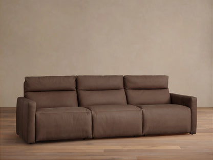 Dark brown tailored leather Rowland 3-piece motion modular sofa, front view, against a light beige wall and wood floor.