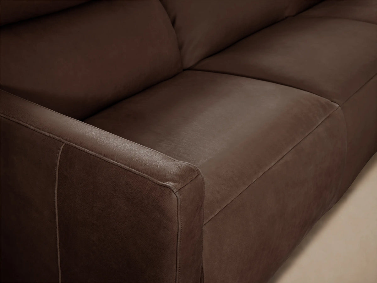 Rowland Tailored Leather Three-Piece Motion Modular Sofa in warm taupe, with sleek lines, against a beige wall and wood floor.