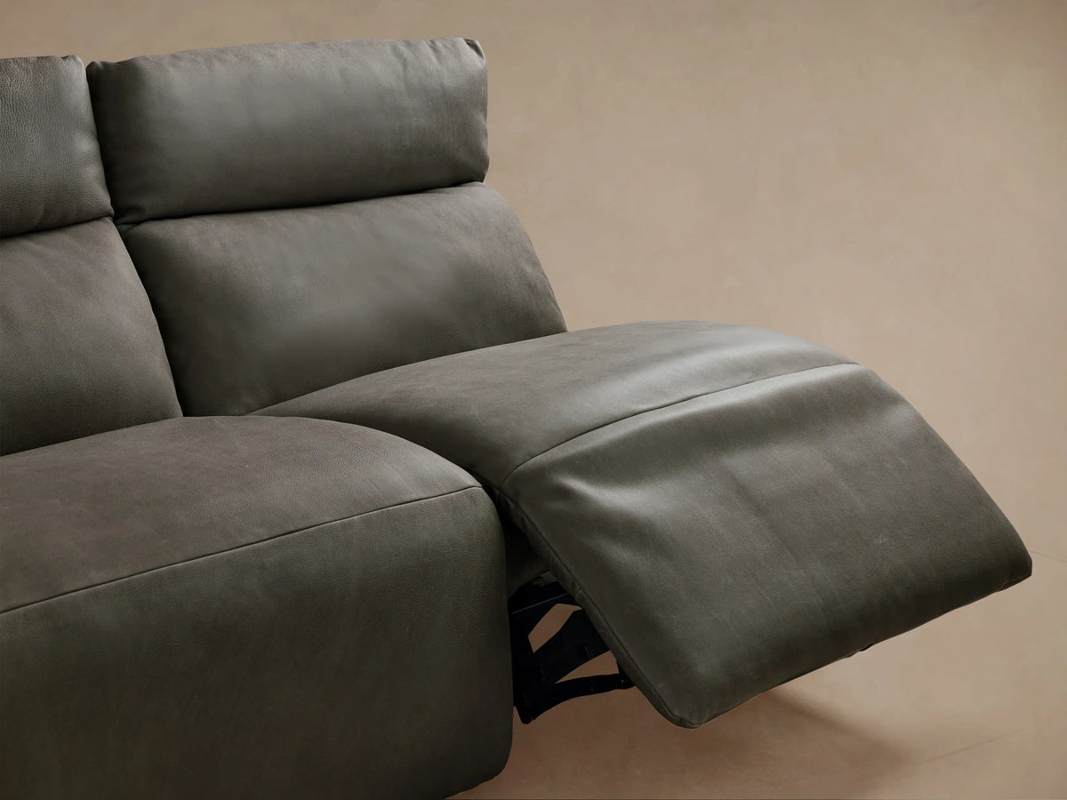 Rowland Tailored 4-piece charcoal leather armless modular sofa. Leftmost section reclined, others upright, on wood floor.