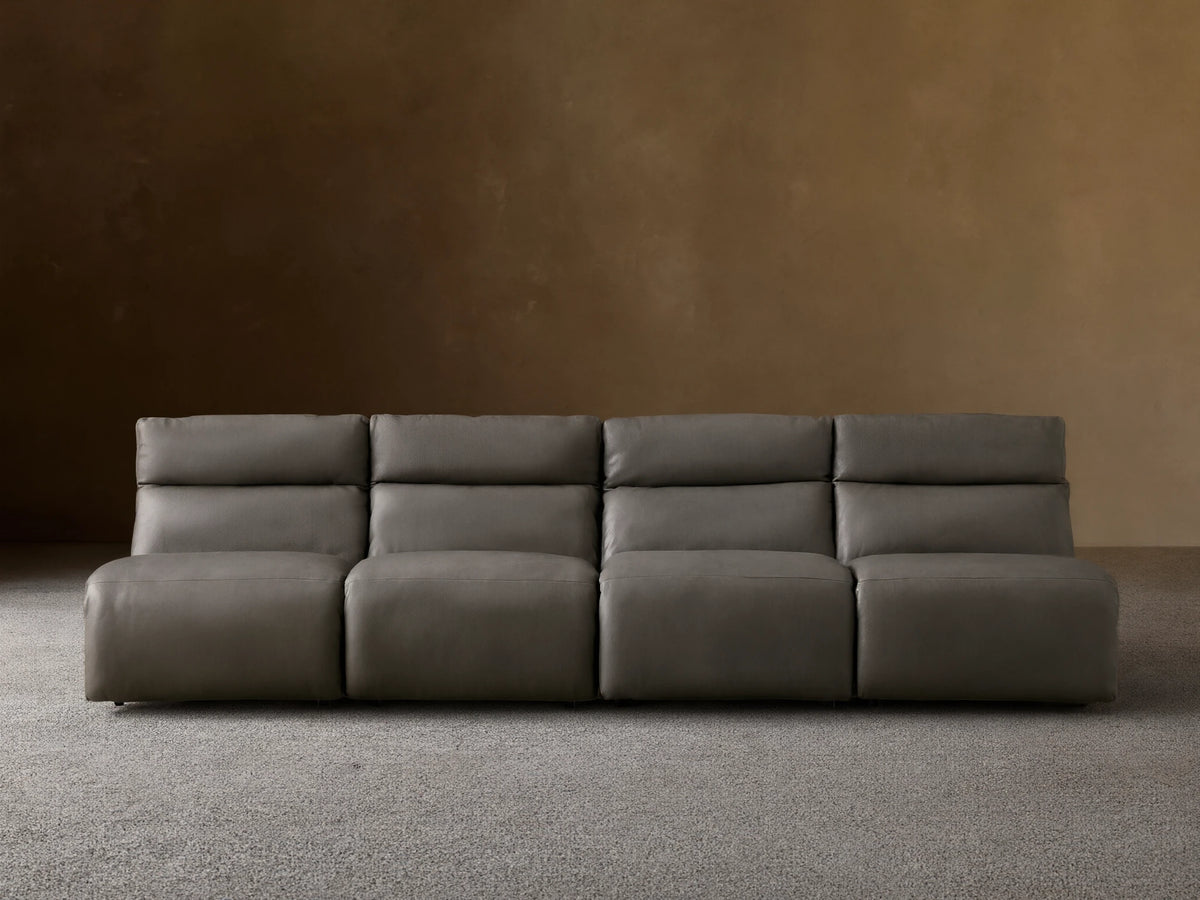 Rowland Tailored charcoal gray leather four-piece armless modular sofa on a wooden floor, against a light brown wall.