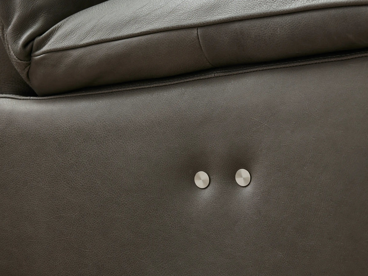 Close-up of an ebony leather Rowland Armless Motion Modular Sofa section, reclined with extended footrest.