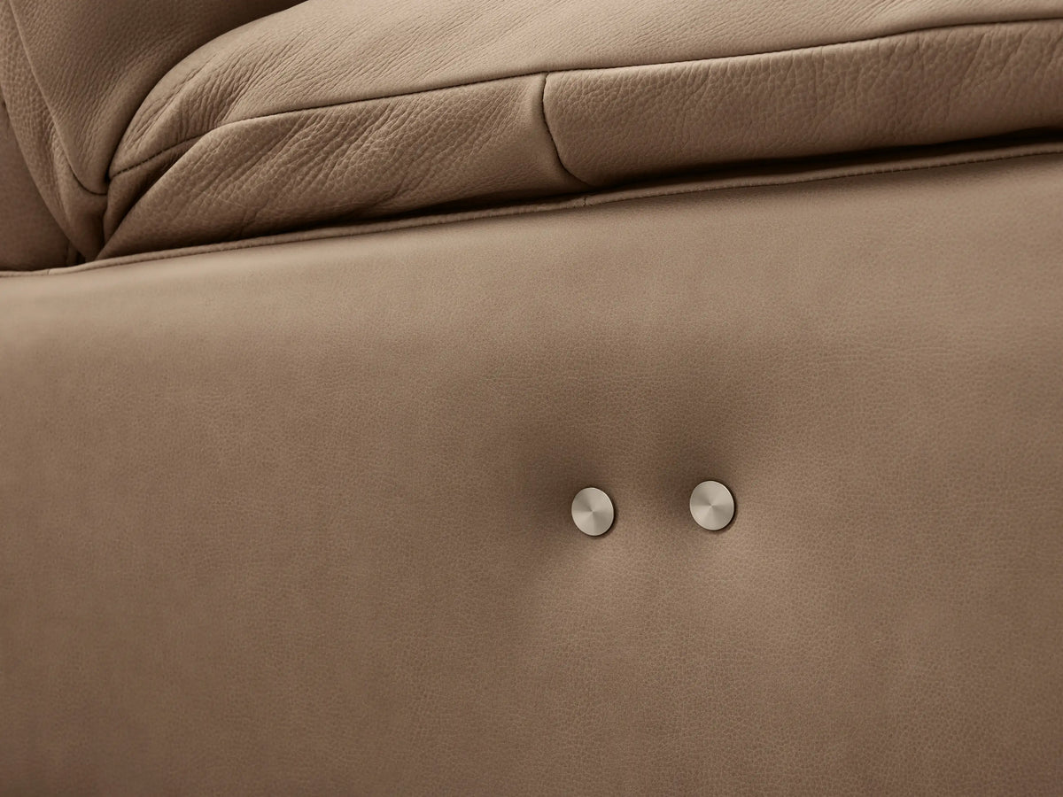 Rowland Tailored four-piece armless motion modular sofa in light taupe leather, centered on a wood floor against a beige wall.