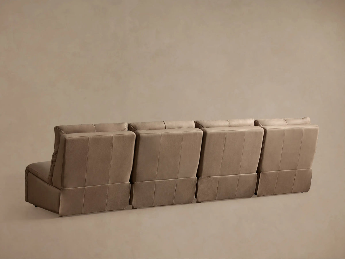 Close-up of a light beige leather Rowland Armless Motion Modular Sofa section with footrest extended & backrest reclined.