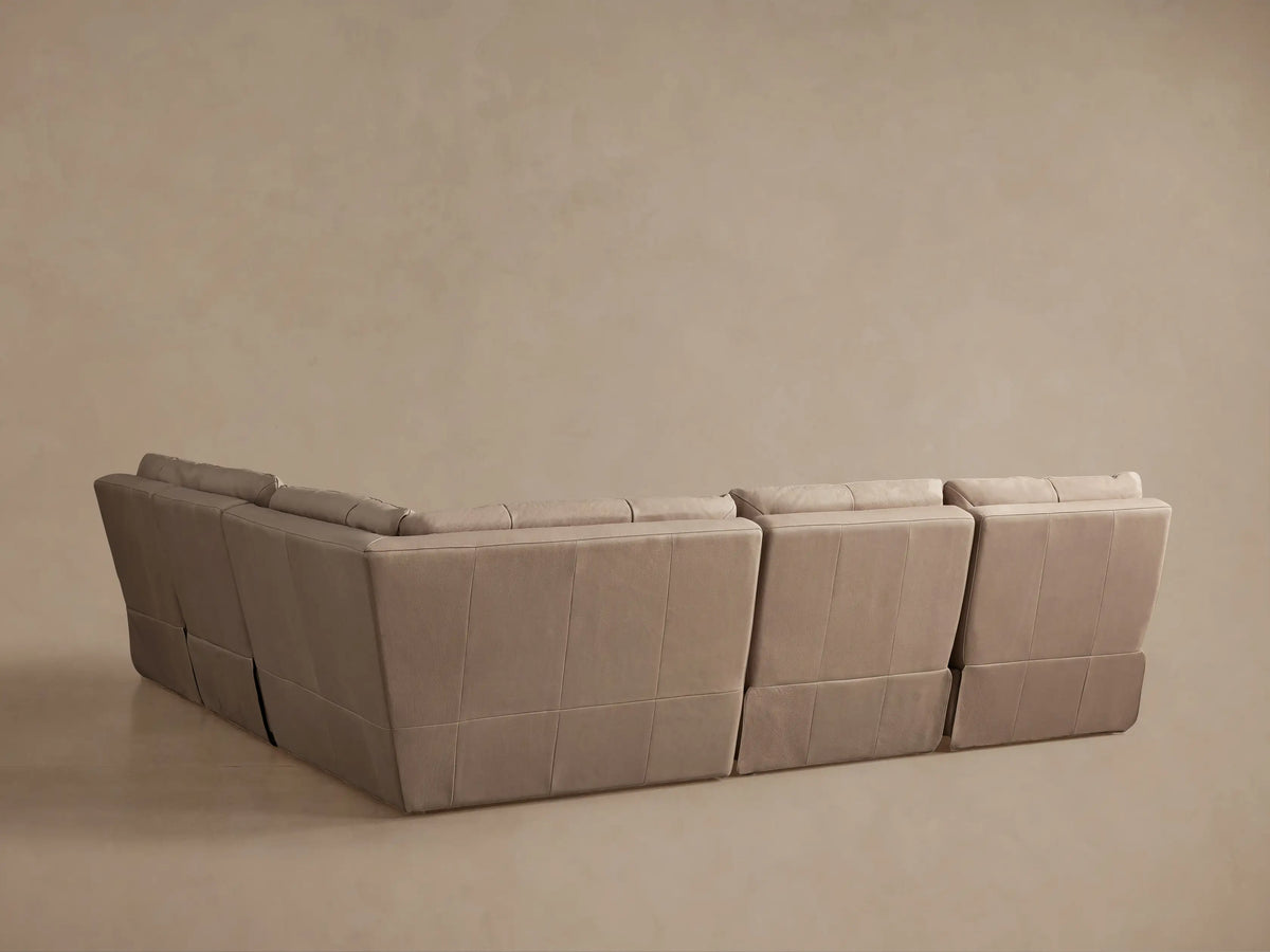 Light taupe Rowland Tailored Leather sectional, armless section reclined, footrest elevated, backrest angled back.