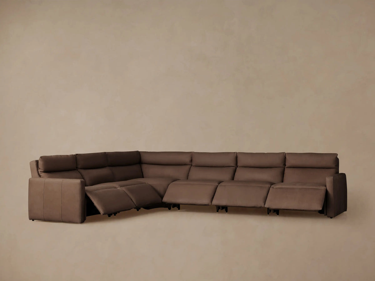 Back view of a brown Rowland Tailored Leather Six-Piece Motion Sectional, showing its L-shape and tailored seams on all sections.