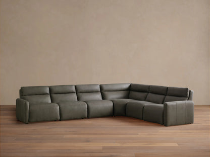 Grey-green Rowland Tailored Leather Six-Piece Motion Sectional, L-shaped, against a light wall on a wood floor.