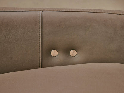 Light taupe Rowland Tailored Leather Six-Piece Motion Sectional, L-shaped, against a beige wall on a wooden floor.