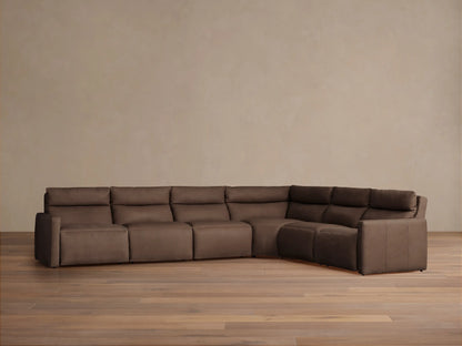 Rowland Tailored six-piece L-shaped motion sectional in dark brown leather, placed against a beige wall on a wood floor.