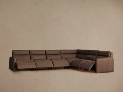 Angled back view of a dark brown Rowland Tailored Leather Six-Piece Motion Sectional, L-shaped, against a plain light brown wall.
