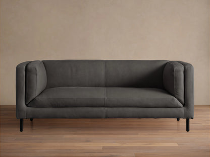 Front view of a modern dark grey Malta Leather Sofa with distinctive square arms, two seat cushions, and black recessed legs.