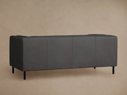 Side profile of a dark gray Malta Leather Sofa, showing the armrest, side panel with vertical seams, and black metal legs.