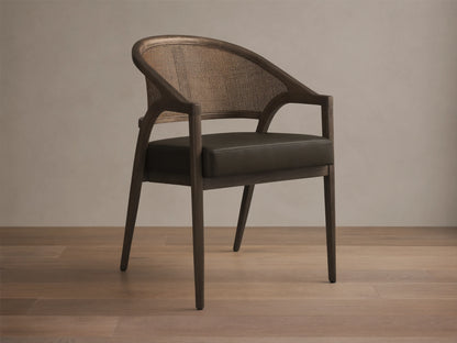 Front view of the Aimee Faux Leather Dining Arm Chair, featuring a dark oak frame, woven rattan back, and dark green faux leather seat.