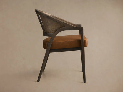 Front view of an Aimee Faux Leather Dining Arm Chair with a dark wood frame, natural rattan back, and brown faux leather seat.