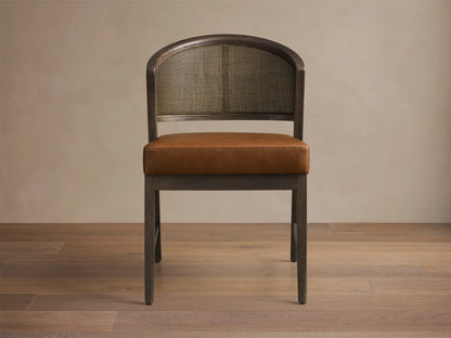 Front view of the Aimee Faux Leather Dining Side Chair with a dark wood frame, natural rattan cane back, and brown faux leather seat.