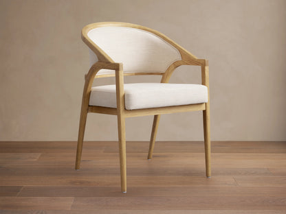 Aimee Upholstered Back Dining Arm Chair with solid oak frame, light beige fabric, and lacquered wood finish in side view.