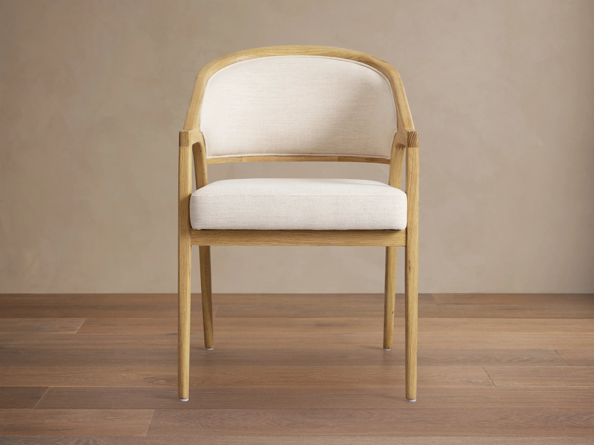 Side view of a Honey Aimee Upholstered Back Dining Arm Chair, featuring a dark wood frame and rich, upholstered seat and back.