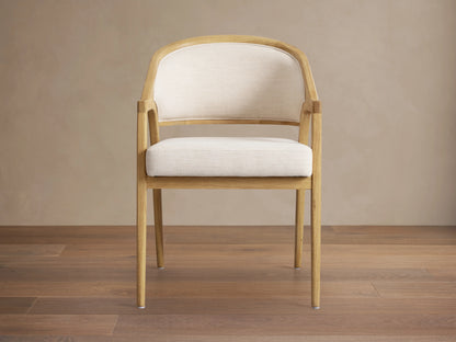 Side view of a Honey Aimee Upholstered Back Dining Arm Chair, featuring a dark wood frame and rich, upholstered seat and back.