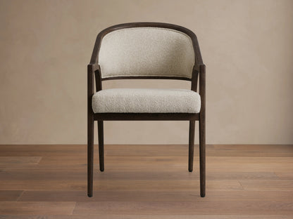 Aimee Dining Arm Chair with upholstered cream back and seat, solid oak frame in dark brown, on a wooden floor.