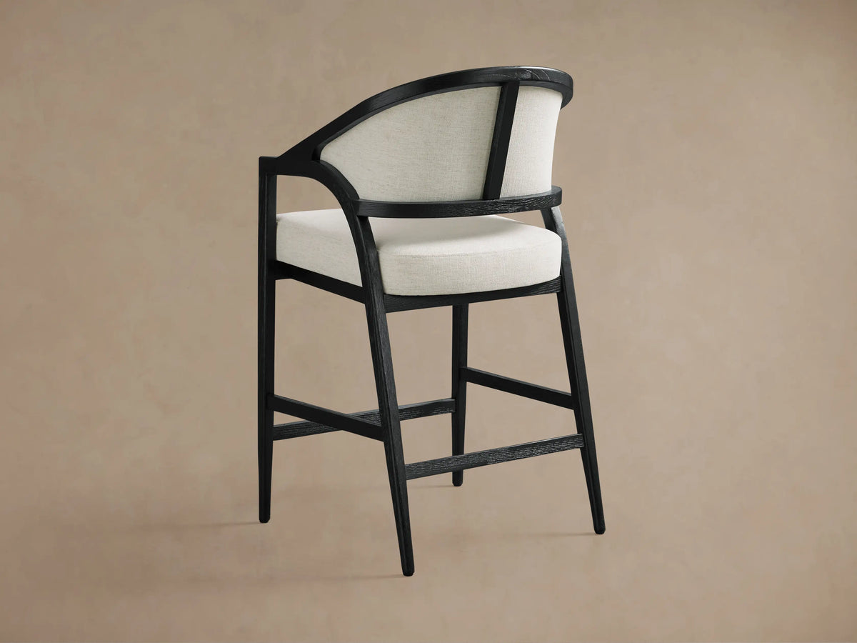Aimee Upholstered Back Counter Stool with solid oak frame, black lacquer finish, and beige upholstered back and seat.