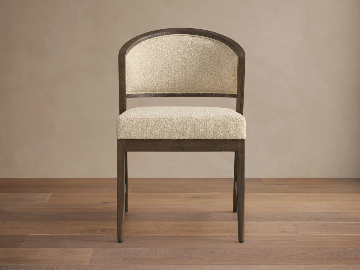 Aimee Upholstered Back Dining Side Chair with dark wood frame, beige cushioned seat and backrest, set on a wooden floor.