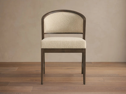 Aimee Upholstered Back Dining Side Chair with dark wood frame, beige cushioned seat and backrest, set on a wooden floor.