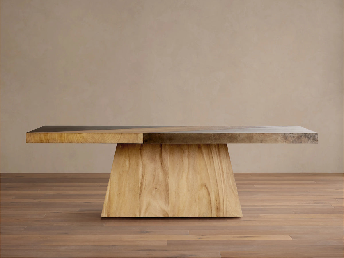 Almeria Dining Table made of guanacaste wood and oxidized steel, rectangular top with unique patinas, on a tapered wooden base.