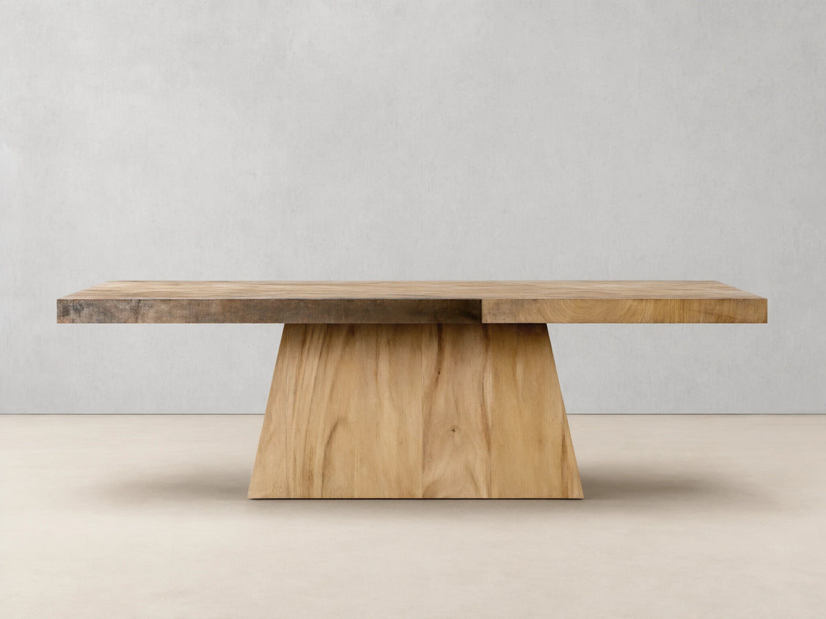 Almeria Dining Table made of guanacaste wood and oxidized steel, rectangular top with unique patinas, on a tapered wooden base.