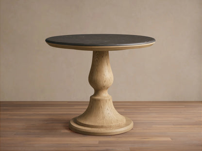 Round Amelia Bistro Table featuring a dark bluestone top and a light oak wood pedestal base, standing on a wooden floor.