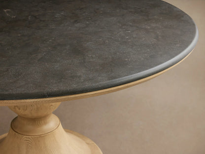 Round Amelia Dining Table with white Carrara marble top and sculpted oak pedestal base in a bright dining nook.