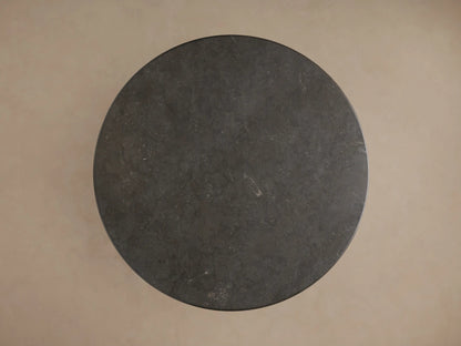 Amelia Dining Table: close-up of dark, textured bluestone top with a rounded edge, light oak apron & carved pedestal base.