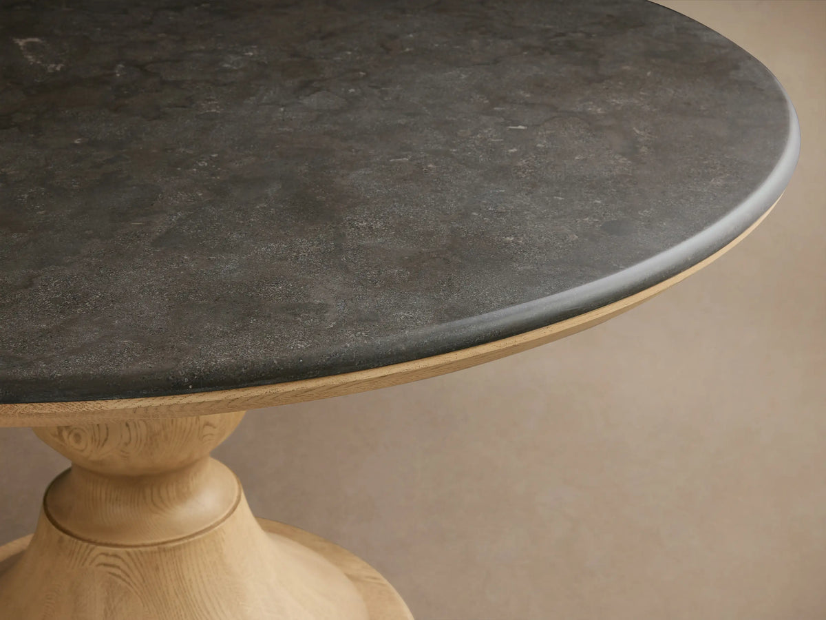 Amelia Dining Table with a round Carrara marble top and light oak pedestal base, set in a bright dining nook.