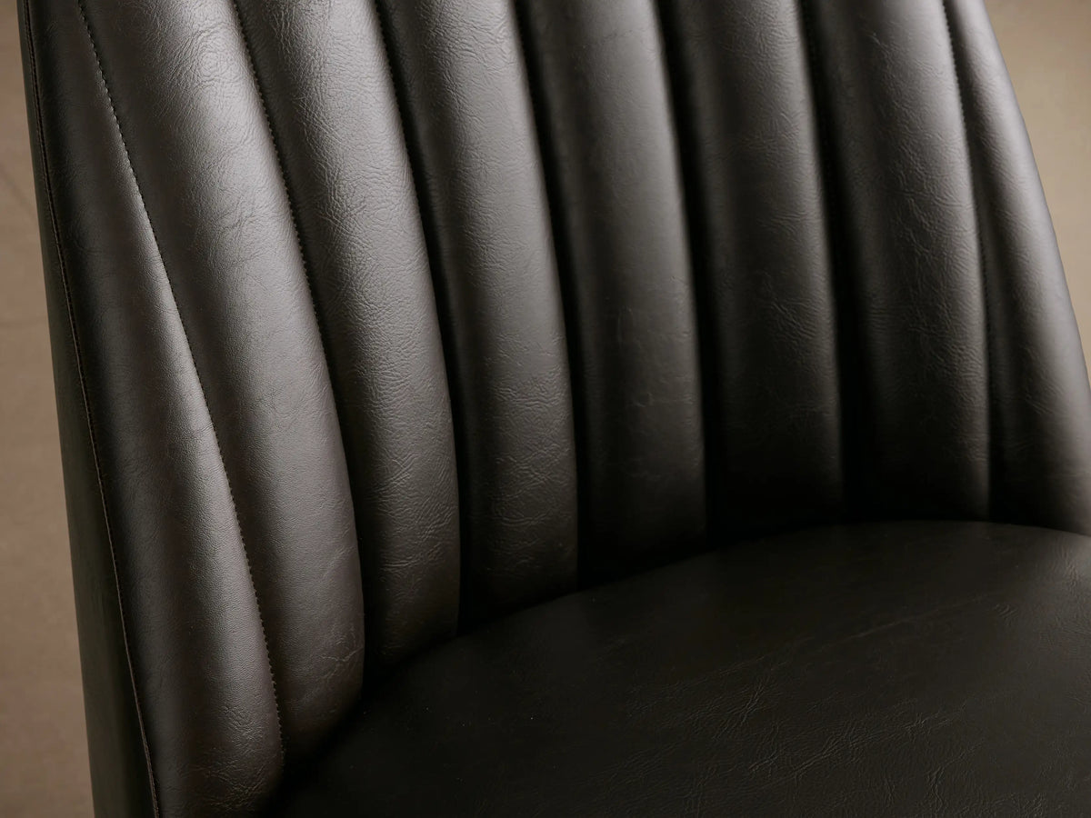 Arco Faux Leather Dining Chair in dark brown, with a channel-tufted backrest, padded seat, and tapered wooden legs.